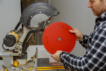 Carpenter replacing a rotary cutters blade in the saw