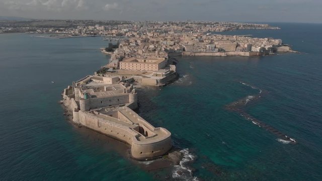 Aerial shot: Ortigia island with Castello Maniace citadel in front. UNESCO Italy