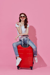 young woman with suitcase isolated on white