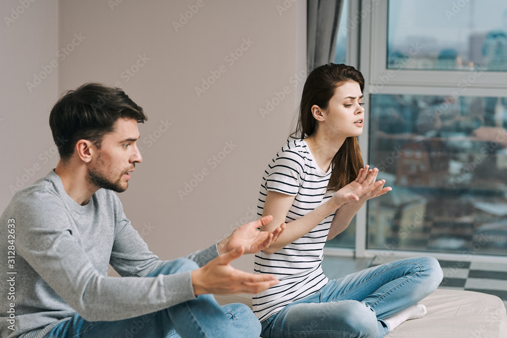 Wall mural young couple sitting on sofa at home