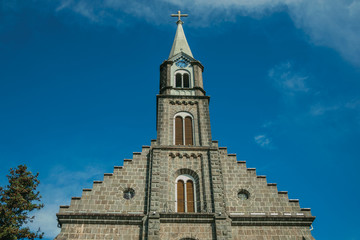 Fototapeta na wymiar Church facade with steeple and cross in Gramado