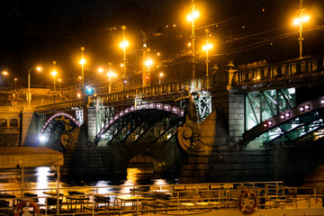 A bridge in the center of Prague illuminated by bright lights