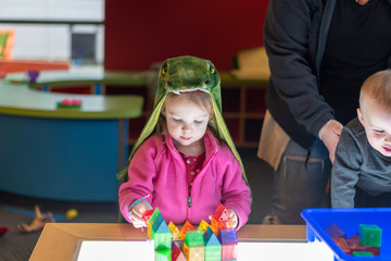 Little kids playing with colorful blocks at the library
