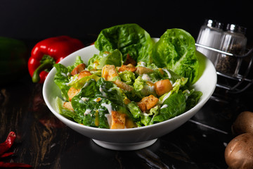 A plated caesar salad with dark background