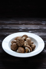 Shiitake mushrooms on the wooden background.
