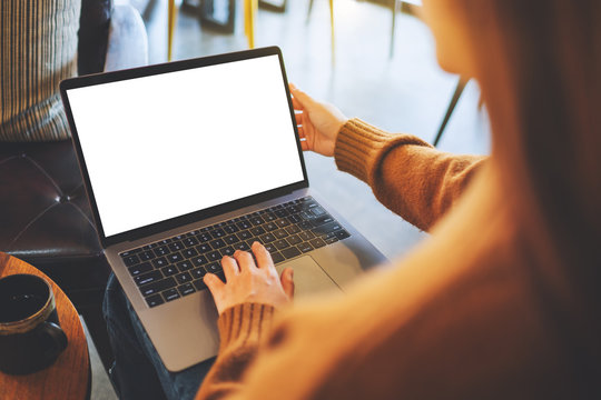 Mockup image of a woman using and typing on laptop computer with blank white desktop screen