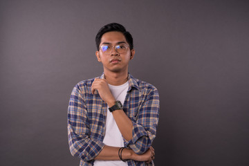 Asian teenager with casual outfit and serious face reaction.Studio shot.
