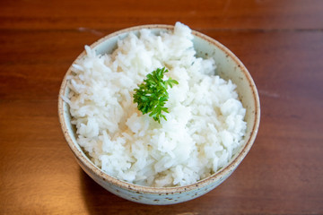 Small bowl of white rice with vegetable decorated on top.