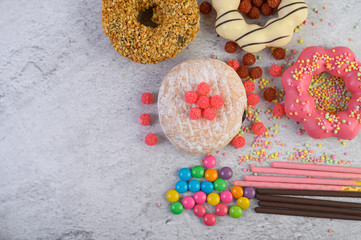 Donuts decorated icing and sprinkles on white background top view