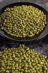 Mung beans on the plateon the black cement floor.