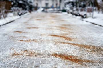 Walkway sprinkled with salt mixtures and sand. De-icing chemicals on pavement. Prevent slipping on road with sand and reagents - technical salt. Icy road and  danger of injury on slippery road