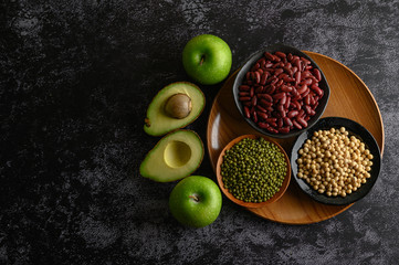 legumes and fruit on a black cement floor background.