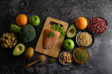 Fototapeta na wymiar legumes, fruit, and Salmon fish pieces on a wooden chopping board.