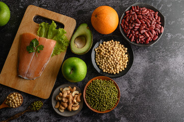 legumes, fruit, and Salmon fish pieces on a wooden chopping board.