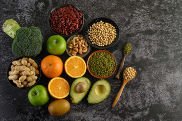legumes and fruit on a black cement floor background.