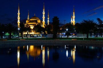 Fototapeta na wymiar Blue Mosque lit at dusk with reflection in fountain Istanbul Turkey