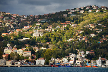 Fototapeta na wymiar Sun on the hillside of Buyukdere Turkey with Seine fishing boats on the Bosphorus Strait
