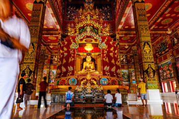 Gold buddha in temple with all people faithful