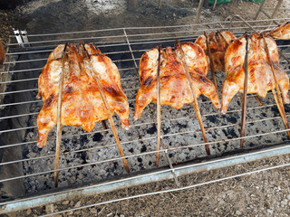 Grilled chicken on charcoal grill, Meat skewers cooked over heat on the stove, Street food in...