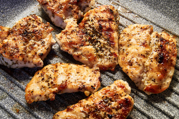 pieces of fried chicken breast. Grilled poultry steak cooked on a grill pan