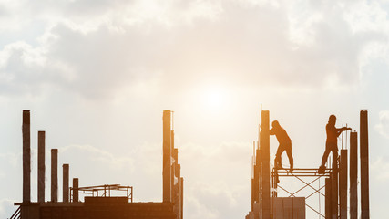 Silhouette of construction worker working on site for roof structure