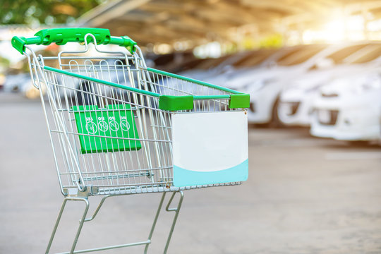 New Supermarket Trolley On The Street And Blur Of Car In Parking Lot