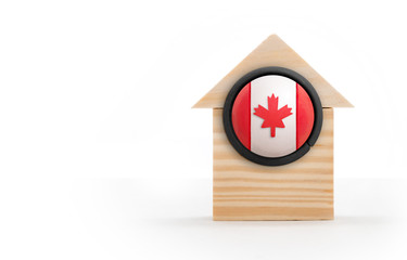 Wood block house with large Canada flag button. Copy space. Isolated on white. 