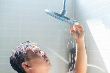 Worried Asian man take a shower in the bathroom and water was turned off. He looking to shower