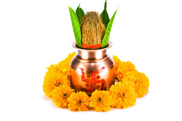 Copper kalash with coconut, mango leaf, and marigold flower isolated on white background
