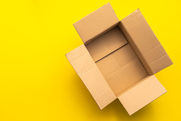 Top view empty brown post or carton box on yellow paper background