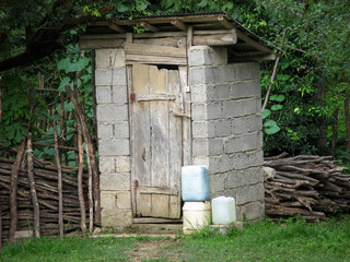 Rustic Wc. Rustic outdoor toilet stands in the garden. Rural lifestyle, latrine, wc, outhouse,...