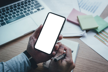 Mockup image blank white screen cell phone.man hand holding texting using mobile on desk at office.background empty space for advertise text.people contact marketing business,technology 
