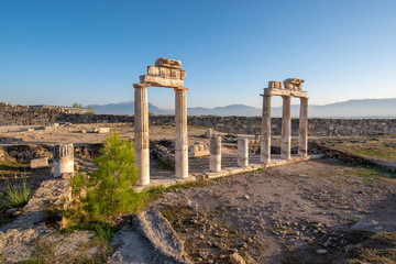 Fototapeta na wymiar Beautiful view of the ancient ruins of the Roman city of Hierapolis in Pamukkale, Turkey. The site is a UNESCO World Heritage site near the city of Denizli. 