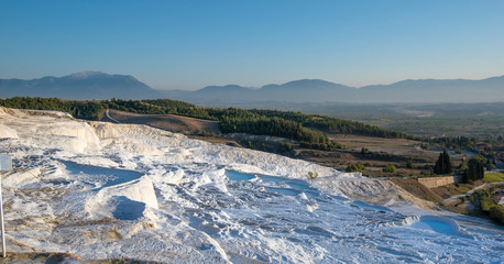 Beautiful sunset and Natural travertine pools and terraces in Pamukkale. Cotton castle in southwestern Turkey near Denizli, Hot springs white colored with turquoise blue water used like a bath
