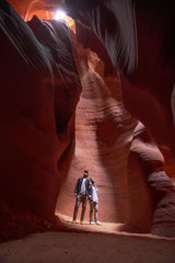 Happy couple moslem posing exploring inside the Grand Canyon, eroded sandstone rock in slot canyon,...