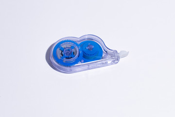 Office tape corrector in a transparent case with blue details on a white background.