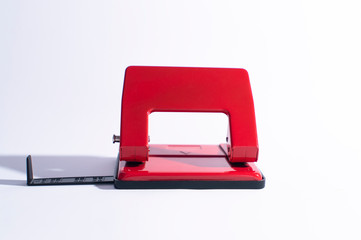 Red hole punch on a white background. Hole puncher with extended paper limiter A4. Front view of...