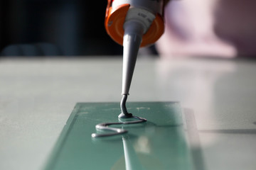 Craftsmen use silicone glue to fix glass work.