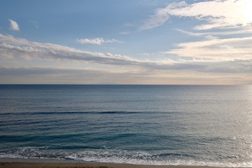 blue sea horizon under sunny clouds sky. waves against beach