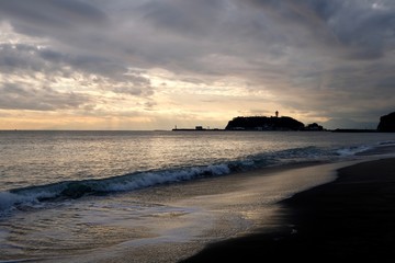Beautiful sunset of Enoshima island in Kanagawa Japan. Sea waves against beach. 