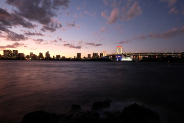 Panoramic view of rainbow bridge in tokyo at sunset. long exposure