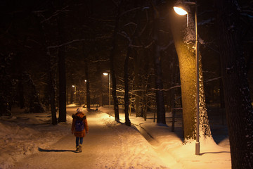lonely child walkink in the night winter park