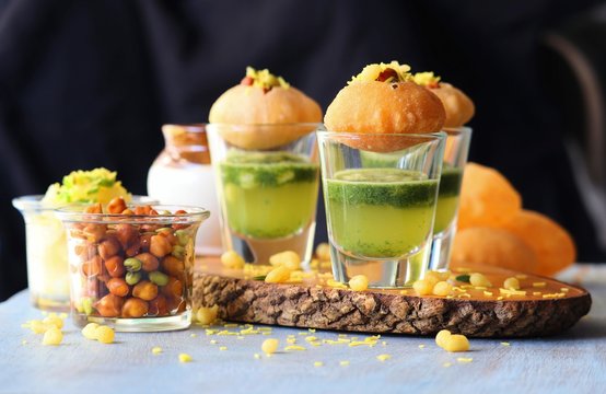Pani Puri shots, Indian street snack made of fried puries, mint chutney, sprouts and boiled potatoes. Indian Chat