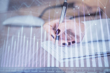 Multi exposure of hands making notes with forex chart huds. Stock market concept.