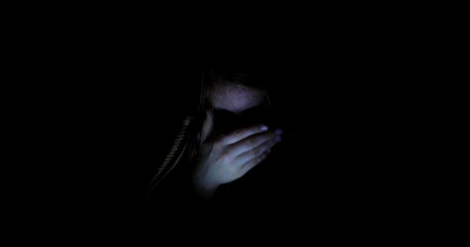 Little girl watching content on her smartphone. The pitfalls of social networks. The child secretly communicates over the Internet at night. Stabilized video.