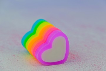 Colorful heart-shape erasers in arrangement for Valentine's day as background.