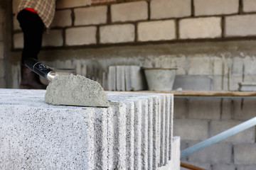 Cement or cement powder with a trowel laid on a brick for construction.