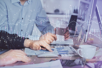 Multi exposure of chart with man typing on computer in office on background. Concept of hard work.