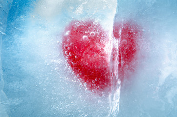 Red heart frozen in ice with a big crack, a symbol of love or betrayal or separation
