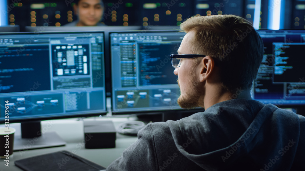 Poster IT Specialist Working on Personal Computer with Monitors Showing Coding Language Program. Technical Room of Data Center. 